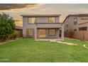 Spacious backyard with lush lawn, covered patio, mature trees, and block fence at 41158 W Cahill Dr, Maricopa, AZ 85138