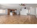 Open-concept living room featuring tile floors, stainless steel appliances, wood cabinets, and island at 41158 W Cahill Dr, Maricopa, AZ 85138