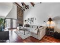 Bright living room with a stone fireplace, wood beam ceilings, and a comfortable sectional sofa at 4242 N 44Th St, Phoenix, AZ 85018