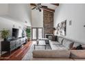 Comfortable living room with a stone fireplace, wood beam ceilings, and a gray sectional sofa at 4242 N 44Th St, Phoenix, AZ 85018