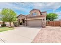 Beautiful two-story home featuring stone accents, a well-manicured lawn, and an attached two-car garage at 7812 S 67Th Ln, Laveen, AZ 85339