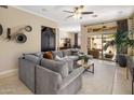 Spacious living room with gray sectional sofa, neutral walls, and access to outdoor patio at 8934 E Calle Buena Vis, Scottsdale, AZ 85255