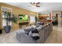 Open living room with a large gray sectional, ceiling fan, and view into the kitchen at 8934 E Calle Buena Vis, Scottsdale, AZ 85255