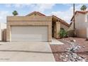 Single story house with a two-car garage and desert landscaping for low maintenance living at 11290 E Poinsettia Dr, Scottsdale, AZ 85259
