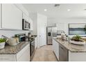 Modern kitchen featuring stainless steel appliances, granite countertops, and ample cabinet space at 11858 E Cliffrose Ln, Florence, AZ 85132