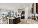 Modern kitchen featuring an island, stainless steel appliances, and an adjacent dining area at 11890 E Cliffrose Ln, Florence, AZ 85132