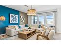Stylish living room featuring modern furniture, a patterned accent wall, and large windows for natural light at 12247 E Agave Ln, Florence, AZ 85132