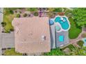 A luxurious backyard oasis featuring a sparkling pool, shaded patio, and lush greenery at 1292 N Renee Ave, Gilbert, AZ 85234