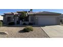 Charming single-story home with well-maintained landscaping and a two-car garage at 15753 W Kino Dr, Surprise, AZ 85374