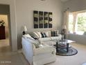 Bright living room featuring comfortable seating, modern art, and a view of the backyard at 15753 W Kino Dr, Surprise, AZ 85374