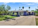 Blue single-story home with a spacious driveway and mature trees at 1639 W Indianola Ave, Phoenix, AZ 85015