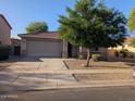 Charming home featuring a neutral color palette, a two-car garage, and a well-manicured desert landscape at 17328 W Pinnacle Vista Dr Dr, Surprise, AZ 85387