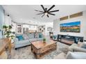 An open concept living room features a modern ceiling fan, fireplace, and desert artwork on display at 17815 W Straight Arrow Ln, Surprise, AZ 85387