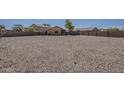 Large gravel backyard with a tall block fence providing ample space for outdoor activities and low maintenance at 20761 N Herbert Ave, Maricopa, AZ 85138