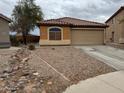 Single-story home featuring neutral stucco, a tile roof, gravel landscaping, and a two-car garage at 20761 N Herbert Ave, Maricopa, AZ 85138