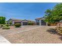 Long driveway leading to multiple garages surrounded by mature landscaping and ample parking at 24372 N 96Th Ln, Peoria, AZ 85383