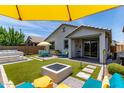 Backyard with an inground hot tub, artificial turf, gas fire pit, and outdoor seating area at 25289 N 143Rd Dr, Surprise, AZ 85387