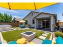 Inviting backyard featuring artificial turf, hot tub, a fire pit and stylish outdoor seating for relaxation and entertainment at 25289 N 143Rd Dr, Surprise, AZ 85387