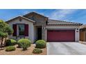 Charming single-story home featuring a two-car garage, well-kept landscaping, and a stylish facade at 25289 N 143Rd Dr, Surprise, AZ 85387