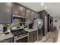 Modern kitchen with stainless steel appliances, grey cabinetry, and tiled backsplash at 25289 N 143Rd Dr, Surprise, AZ 85387