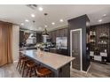 Kitchen featuring a large island with seating, stainless steel appliances, and stylish pendant lighting at 25289 N 143Rd Dr, Surprise, AZ 85387