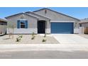 Charming single-story home with a blue garage door, desert landscaping, and nice window shutters at 37172 W Parador Ln, Maricopa, AZ 85138