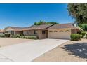 Charming brick home featuring a long driveway, two-car garage and mature landscaping at 4402 W El Caminito Dr, Glendale, AZ 85302