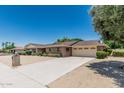 Expansive ranch-style home featuring a long driveway, two-car garage and mature landscaping at 4402 W El Caminito Dr, Glendale, AZ 85302