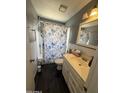Cozy bathroom featuring a tiled shower, vanity, and floral shower curtain at 4823 W Palm Ln, Phoenix, AZ 85035