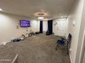 Spacious living room features neutral carpeting, a ceiling fan, and a front door at 4823 W Palm Ln, Phoenix, AZ 85035