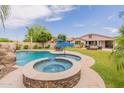 Expansive backyard featuring a sparkling pool, spa, and covered patio with ample seating and dining areas at 550 W Powell Way, Chandler, AZ 85248