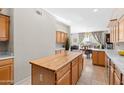 Kitchen featuring wooden cabinets, tiled floor, and an island with a butcher block top and view to the dining area at 6002 N 5Th Pl, Phoenix, AZ 85012