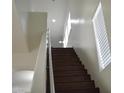 Staircase featuring white walls, handrails and dark wood stairs at 6620 W Shaw Butte Dr, Glendale, AZ 85304