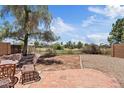 Spacious backyard with brick patio, gravel area, and view of community green space, and mature landscaping at 706 N El Dorado Dr, Gilbert, AZ 85233