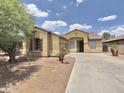 View of single-story home with a spacious driveway, a tile roof, and desert landscaping at 7116 W Sophie Ln, Laveen, AZ 85339