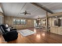 Cozy living room with hardwood flooring, complemented by a stylish ceiling fan and wood-paneled walls at 8103 E Southern Ave # 119, Mesa, AZ 85209
