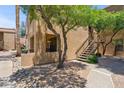 Exterior view of a well-maintained condo building with desert landscaping and outdoor staircase at 8787 E Mountain View Rd # 1100, Scottsdale, AZ 85258