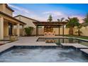 Backyard pool area featuring a built in outdoor kitchen with string lights and a stone fireplace at 10331 E Starion Ave, Mesa, AZ 85212