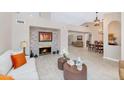 Bright living room featuring stone fireplace, and open to dining area, with neutral tones and tile flooring at 12730 N 90Th Way, Scottsdale, AZ 85260