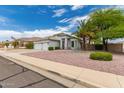 Charming home with a desert landscape, palm trees, and 3-car garage at 13368 W Rimrock St, Surprise, AZ 85374