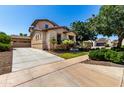 Inviting two-story home featuring a well-maintained yard, long driveway, and attached three-car garage at 13602 N 149Th Ave, Surprise, AZ 85379
