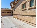 Side exterior view of the home highlighting the stucco siding and adjacent three car garage at 13602 N 149Th Ave, Surprise, AZ 85379