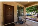 Charming front porch with a rocking chair, smooth river rocks, and welcoming entryway at 13602 N 149Th Ave, Surprise, AZ 85379