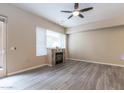 Bright living room with fireplace, modern ceiling fan, and door to the outside at 16 W Encanto Blvd # 110, Phoenix, AZ 85003