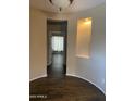 Spacious living room featuring wood-look tile floors, neutral colors, and recessed display nook at 23317 N Arrellaga Dr, Sun City West, AZ 85375