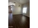 Bright living room boasts wood floors, chandelier, and abundant natural light from a large window at 33055 N Madison Way Dr, San Tan Valley, AZ 85144