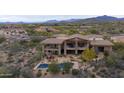 Captivating view of the home exterior highlighting the outdoor pool, stone accents, and desert landscape at 36389 N 105Th Pl, Scottsdale, AZ 85262