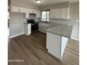 Bright kitchen features stainless steel appliances, white cabinets and granite countertops at 3749 W Gelding Dr, Phoenix, AZ 85053