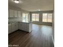 View of the kitchen featuring white cabinetry, laminate countertops and modern flooring at 3749 W Gelding Dr, Phoenix, AZ 85053