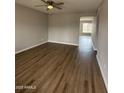 Open living room features modern wood flooring, neutral walls and ceiling fan light fixture at 3749 W Gelding Dr, Phoenix, AZ 85053